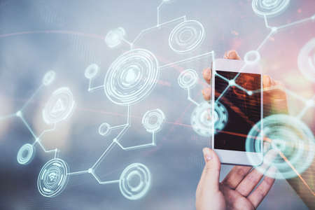 Double exposure of social network sketch hologram and woman holding and using a mobile device.