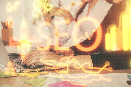 Double exposure of woman hands working on computer and seo hologram drawing. internet search concept.の写真素材