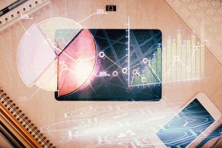Double exposure of forex graph hologram over desktop with phone. Top view. Mobile trade platform concept.の写真素材