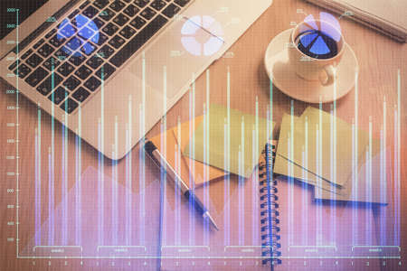 Stock market graph and top view computer on the table background. Double exposure. Concept of financial education.の写真素材