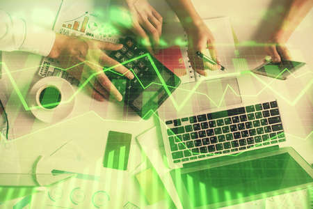 Double exposure of man and woman working together and financial chart hologram drawing. market analysis concept. Computer background. Top View.の写真素材