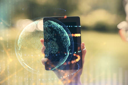 Double exposure of map sketch hologram and woman holding and using a mobile device.の写真素材