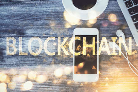 Double exposure of blockchain theme hologram over table with phone. Top view. Crypto technology concept.の写真素材