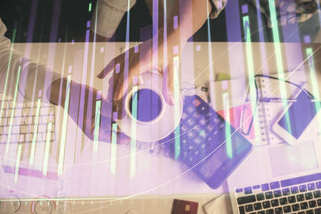 Double exposure of man and woman working together and financial chart hologram drawing. market analysis concept. Computer background. Top View.の写真素材