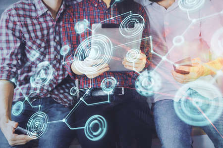 Double exposure of social network theme drawing and man and woman working together holding and using a mobile device.の写真素材