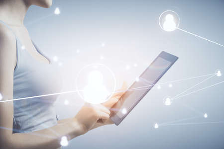 Double exposure of social network sketch hologram and woman holding and using a mobile device.の写真素材