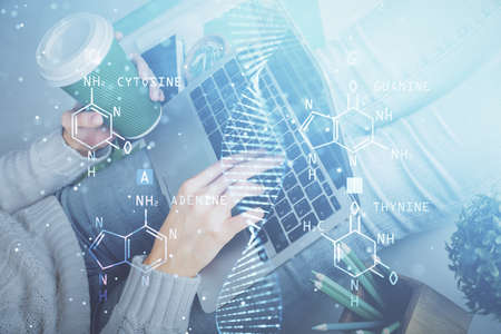 Double exposure of woman hands typing on computer and DNA hologram drawing. Medical education...