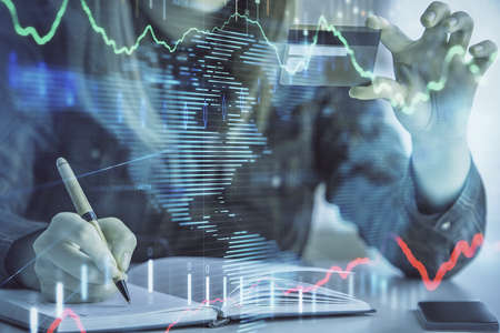 Multi exposure of woman on-line shopping holding a credit card and financial graph drawing. Stock...