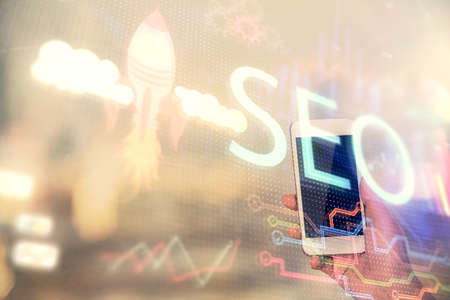 Double exposure of SEO sketch hologram and woman holding and using a mobile device.の写真素材