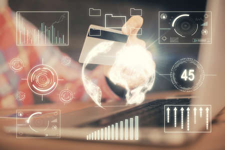 Double exposure of man hands holding a credit card and Forex graph drawing. Stock trading and...