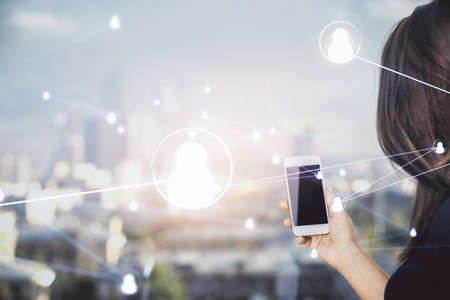 Double exposure of social network sketch hologram and woman holding and using a mobile device.の写真素材