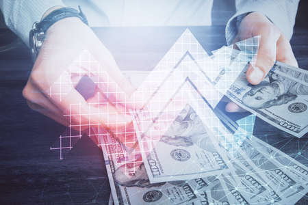 Multi exposure of arrows drawing hologram and USA dollars bills and man hands. Growth concept.