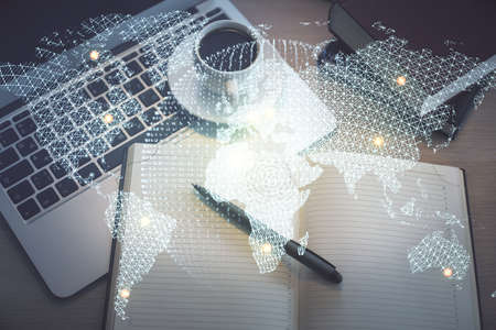 Business theme hologram drawings over computer on the desktop background. Top view. Multi exposure....