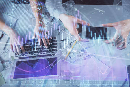 Multi exposure of man and woman working together and forex graph hologram drawing. Financial analysis concept. Computer background. Top View.の写真素材