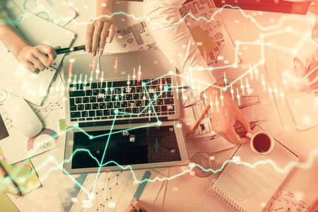 Double exposure of man and woman working together and financial graph hologram. Business concept....