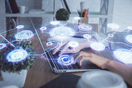 Double exposure of woman hands typing on computer and social network theme hologram drawing. People...