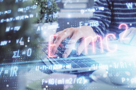 Double exposure of woman hands typing on computer and formula hologram drawing. Education concept.