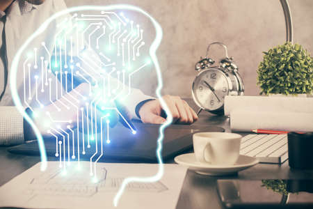 Double exposure of mans hand holding and using a digital device and brain hologram drawing. Data...