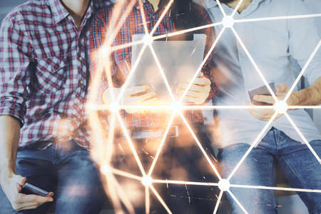 Double exposure of social network theme drawing and man and woman working together holding and using a mobile device.の写真素材