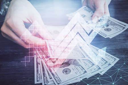 Multi exposure of arrows drawing hologram and USA dollars bills and man hands. Growth concept.の写真素材