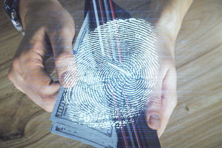 Multi exposure of fingerprint drawing hologram and USA dollars bills and man hands. security concept.の写真素材