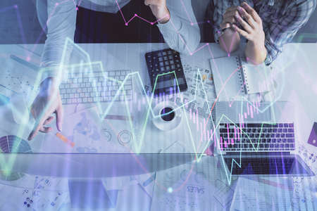 Double exposure of man and woman working together and financial graph hologram drawing. market...