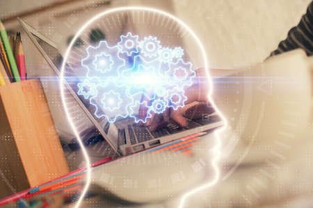 Double exposure of woman hands working on computer and brain hologram drawing. Ai concept.