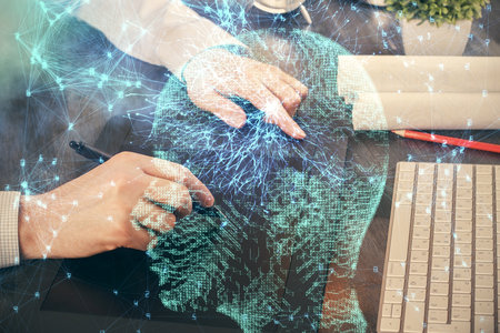 Double exposure of mans hand holding and using a digital device and brain hologram drawing. Data concept.の写真素材
