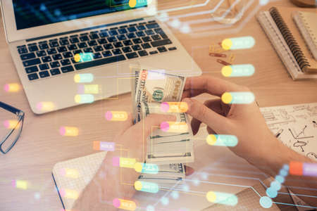 Multi exposure of technology drawing hologram and us dollars bills and man hands. Data conceptの写真素材