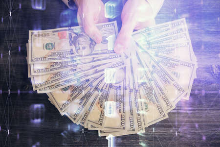 Multi exposure of technology drawing hologram and us dollars bills and man hands. Data conceptの写真素材
