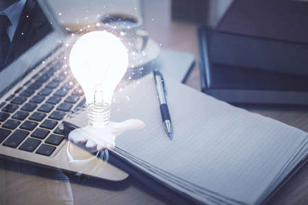 Double exposure of bulb drawing and desktop with coffee and items on table background. Concept of ideas.の写真素材