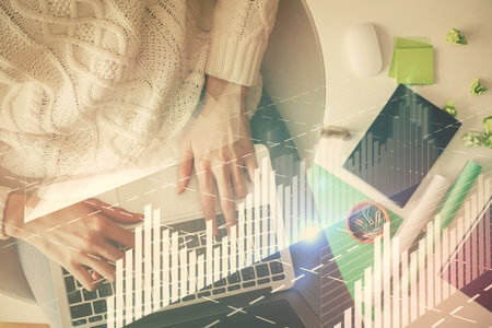 Multi exposure of woman hands working on computer and forex chart hologram drawing. Top View. Financial analysis concept.の写真素材
