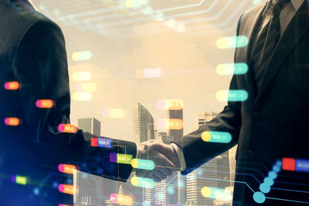 Double exposure of data theme hologram and handshake of two men. Partnership in IT industry concept.