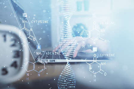 Double exposure of woman hands typing on computer and DNA hologram drawing. Medical education concept.の写真素材