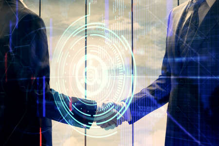 Double exposure of data theme hologram and handshake of two men. Partnership in IT industry concept.