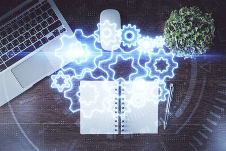Business theme hologram drawings over computer on the desktop background. Top view. Multi exposure....