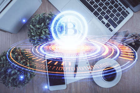 Double exposure of blockchain theme hologram over table with phone. Top view. Crypto technology...