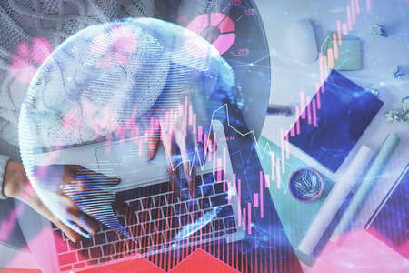 Double exposure of woman hands working on computer and financial theme hologram drawing. Top View....