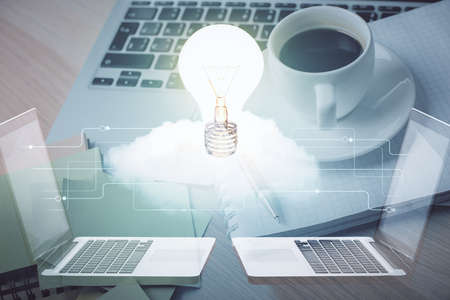 Double exposure of bulb drawing and desktop with coffee and items on table background. Concept of...