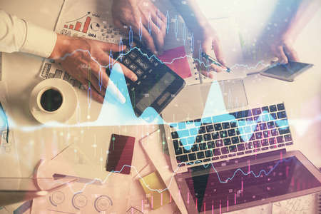 Double exposure of man and woman working together and financial chart hologram drawing. market analysis concept. Computer background. Top View.の写真素材
