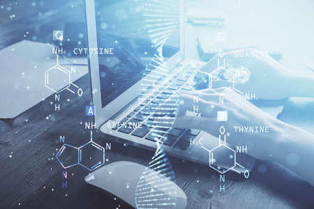 Double exposure of woman hands typing on computer and DNA hologram drawing. Medical education...