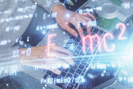 Double exposure of woman hands typing on computer and formula hologram drawing. Education concept.の写真素材