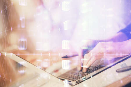 Double exposure of woman hands working on computer and data theme hologram drawing. Tech concept.の写真素材