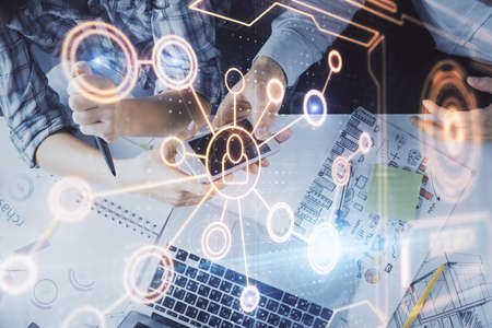 Double exposure of social network theme drawing and man and woman working together holding and using...