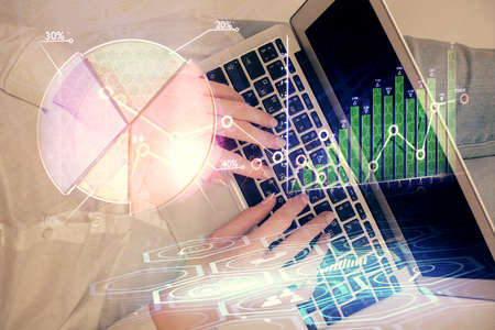 Double exposure of woman hands working on computer and forex chart hologram drawing. Top View....