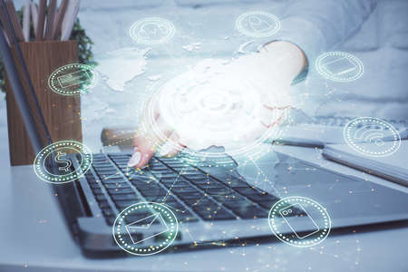 Double exposure of woman hands typing on computer and social network theme hologram drawing. People...