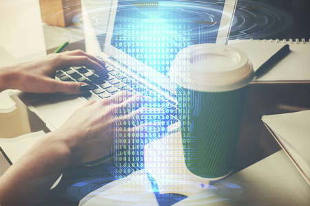 Double exposure of woman hands working on computer and data theme hologram drawing. Tech concept.の写真素材