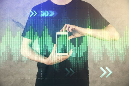 Double exposure of mans hands holding and using a digital device and forex graph drawing. Financial market concept.の写真素材