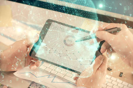 Double exposure of man's hand holding and using a digital device and brain hologram drawing. Data...
