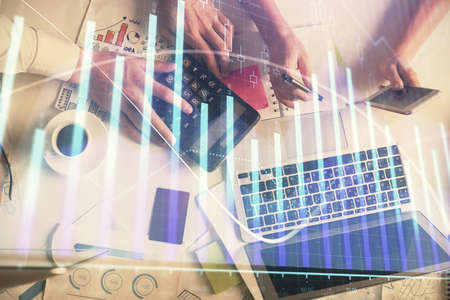 Double exposure of man and woman working together and financial chart hologram drawing. market...